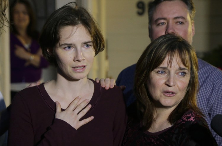 Amanda Knox, left, stands with her mother, Edda Mellas, and talks to the media outside Mellas’ home in Seattle on Friday. Italy’s highest court overturned the murder conviction of Knox and her ex-boyfriend Friday in the 2007 killing of Knox’s roommate, ending the high-profile case.
