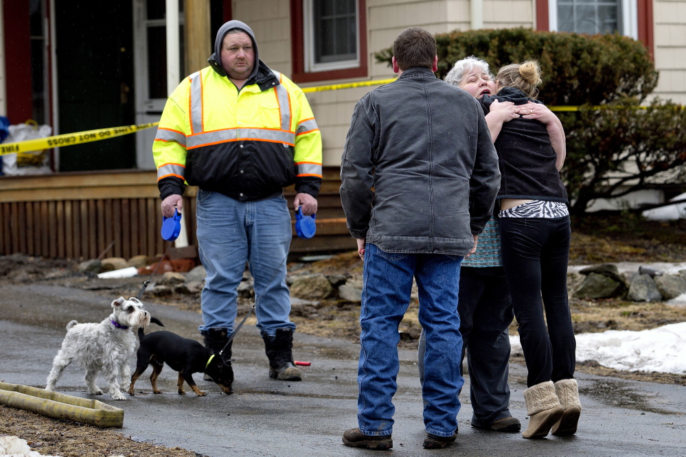Diana Tullos receives a hug from her daughter, Jess Griffin, at right, as Diana’s husband, Rodger, looks on with their two dogs, Sister and Lil’ Bit, after the Tullos’ home caught fire early Friday morning in Lebanon. The couple was awakened by Lil’ Bit, a black Chihuahua, who alerted the couple to the smoke. They escaped with their grandson and dogs.