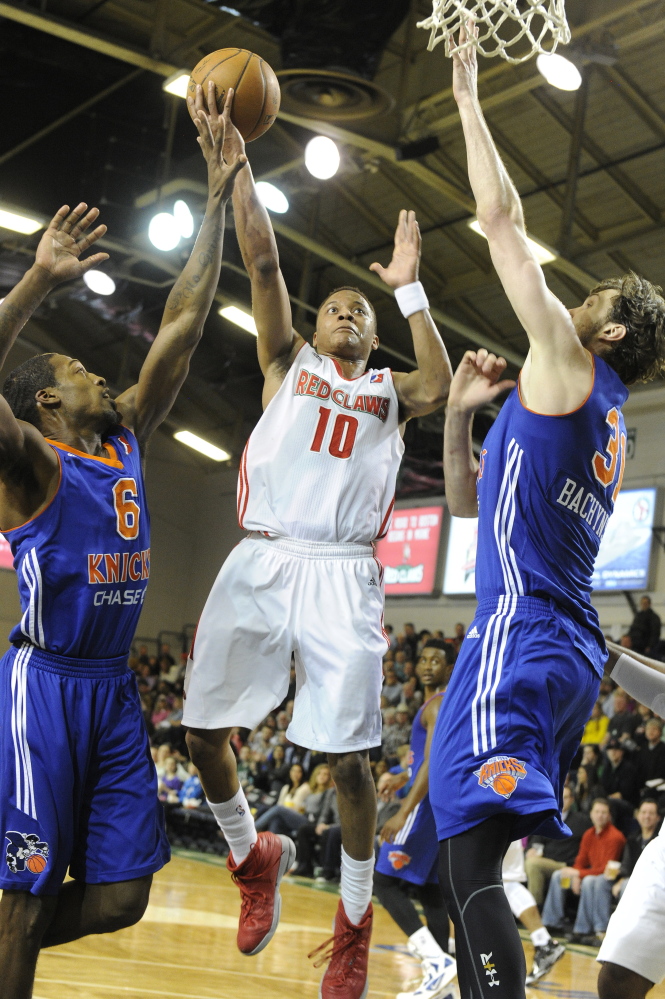 Maine point guard Tim Frazier goes up with a shot between Westchester Knicks defenders Durrell Summers, left, and Jordan Bachynski during the Red Claws’ 102-94 win Friday in Portland.
John Ewing/Staff Photographer