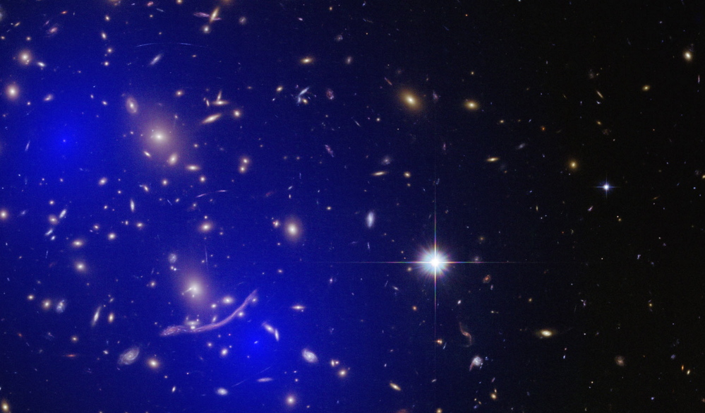 Galaxy cluster A370 with dark matter model overlaid. A new study suggests that dark matter might be able to zip through the universe without slowing or dragging.