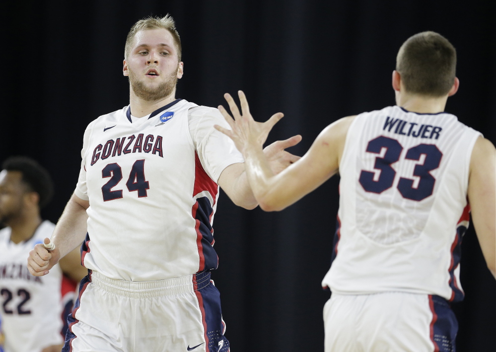 Przemek Karnowski is congratulated by teammate Kyle Wiltjer during Gonzaga’s 74-62 win over UCLA in a South Regional semifinal Friday night in Houston. Karnowski led Gonzaga with 18 points and nine rebounds.
