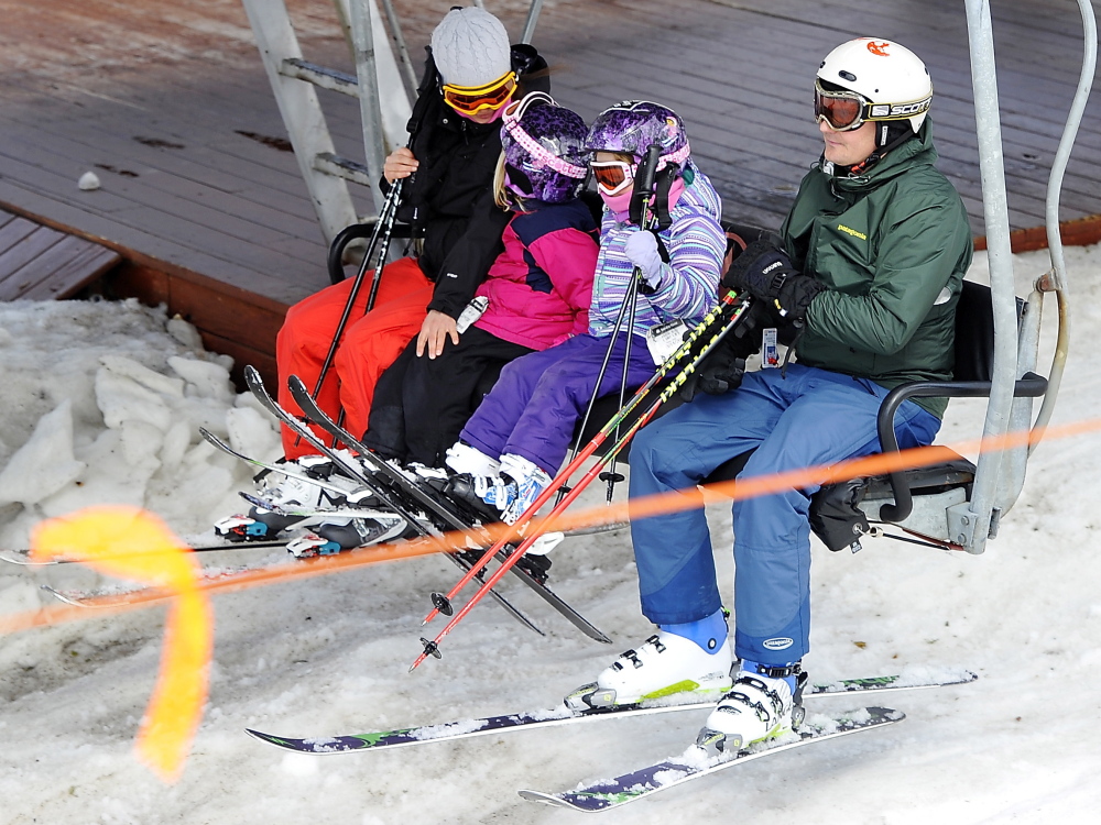 Meredith Laban, left, rides the lift at Sunday River with her husband, Adam Wade, right, and their daughters Alma and Halsey. “What happened (at Sugarloaf) seemed like it was something with the design and they fixed it,” said Meredith Laban.