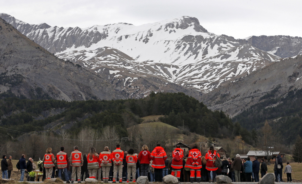 Rescuers stand by in Le Vernet, France, as people attend a memorial for victims of the Germanwings crash in which the co-pilot is suspected of deliberately downing the plane.