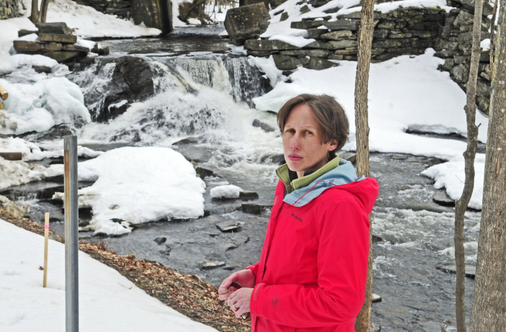 Jennifer Irving, executive director of the Sebasticook Regional Land Trust, stands near the Box Mill dam on Outlet Stream on Friday in North Vassalboro.
