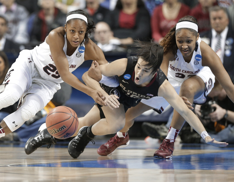 Florida State’s Leticia Romero, center, battles South Carolina’s Tiffany Mitchell, left, and Asia Dozier for the ball in the first half of Sunday’s Greensboro Regional final at Greensboro, N.C.