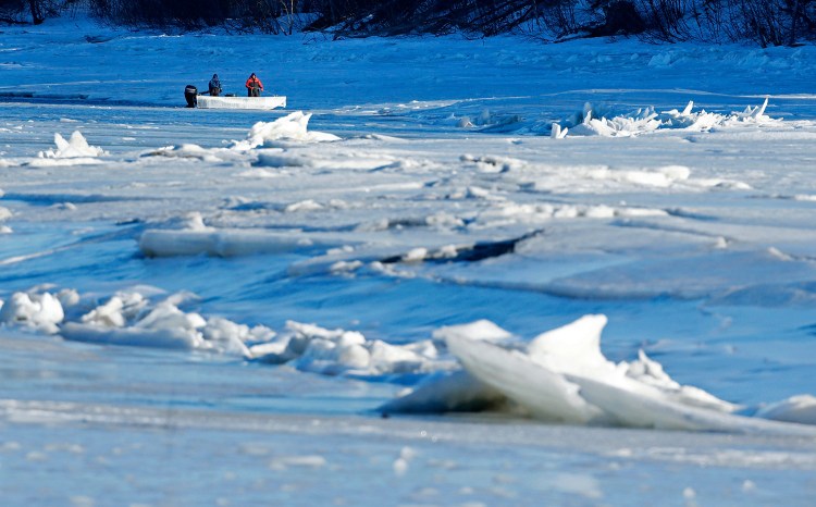 Men use a boat in an attempt to break ice on the Royal River in Yarmouth on Thursday. A state panel is examining the long-lasting snowpack and black river ice to determine the potential for ice jam flooding.
The Associated Press/Robert F. Bukaty