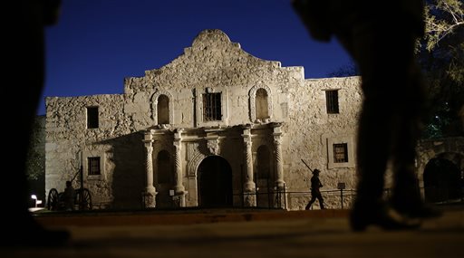 Dan Phillips, a member of the San Antonio Living History Association, patrols the Alamo during a pre-dawn memorial ceremony to remember the 1836 Battle of the Alamo and those who fell on both sides. The Daughters of the Republic of Texas filed suit Monday against the Texas General Land Office for control of more than 30,000 books and artifacts within the historic sites library. (The Associated Press File photo)