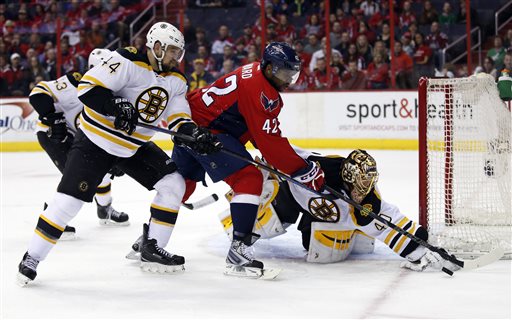 Bruins defenseman Dennis Seidenberg (44), Capitals right wing Joel Ward (42) and goalie Tuukka Rask (40) reach for the puck in the first period Sunday in Washington. The Associated Press