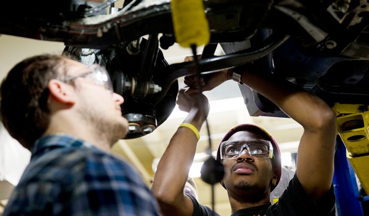 Automotive service technology students work on a car at the Community College of Philadelphia in this October 2014 photo. The National Association for Business Economics has boosted its outlook for U.S. economic improvement in 2015 and 2016, particularly for job growth. The Associated Press