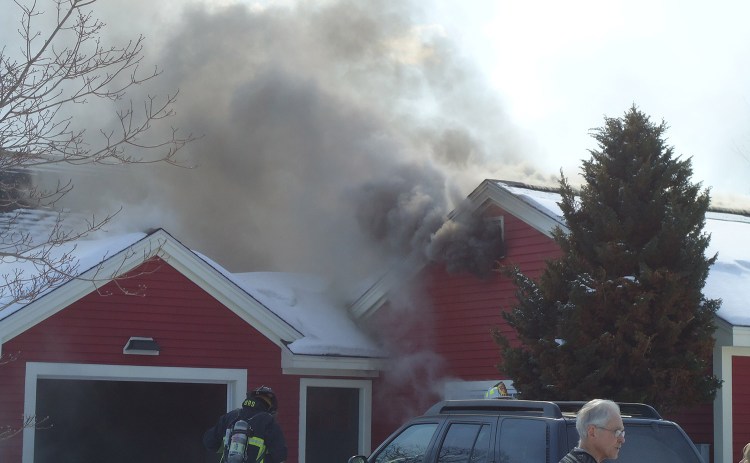 Smoke pours from the home at 146 Scott Dyer Road in Cape Elizabeth on Monday. Fire officials blamed snow and ice for severing a propane line, which fueled an explosion and fire.