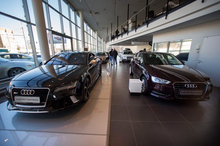 Customers look at cars on display at a  dealership in Moscow. Russian car sales dropped 37.9 percent year-over-year in February,  a sharp contrast to steady rises in Europe overall. The Associated Press