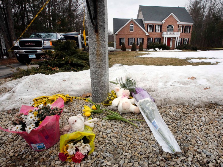 A memorial appears Monday in front of a home in Bedford, N.H. The Associated Press