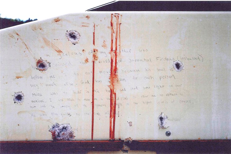 The wall of the boat where Dzhokhar Tsarnaev hid from authorities in Watertown, Mass., shows multiple bullet holes along with bloodstains and Tsarnaev's handwritting. A report from the Massachusetts Emergency Management Agency. says a police officer "fired his weapon without appropriate authority," causing many other officers to believe the bomber was firing at them and leading them to open fire on the boat. The Associated Press / U.S. Attorney's Office