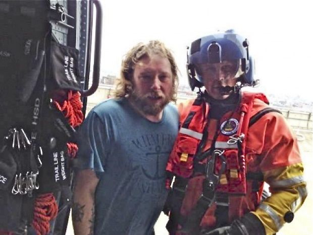 An unidentified man stands with a rescuer from the U.S. Coast Guard after the nine crew of the Liana's Ransom were saved. U.S. Coast Guard photo
