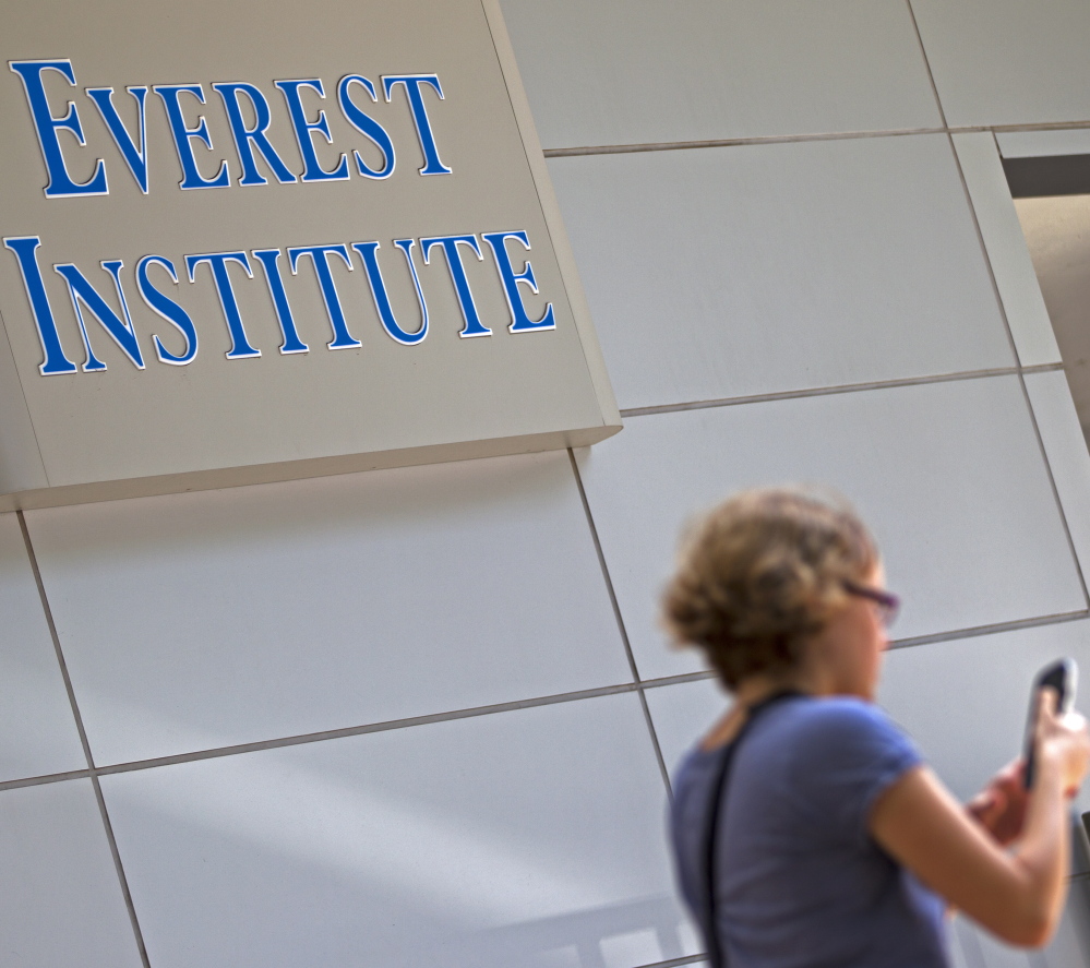 A person walks past an Everest Institute sign in a office building in Silver Spring, Md., last July. (AP Photo/Jose Luis Magana)