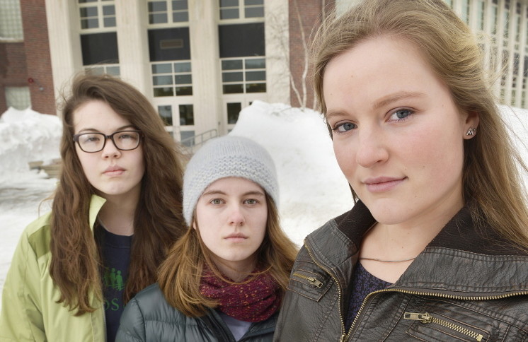 In this February 2015 file photo, South Portland senior class President Lily SanGiovanni, right, joined by two of her supporters, Morrigan Turner, left, and Gaby Ferrell, stand in front of the high school where she led an effort to let students and teachers know they don’t have to say the Pledge of Allegiance.