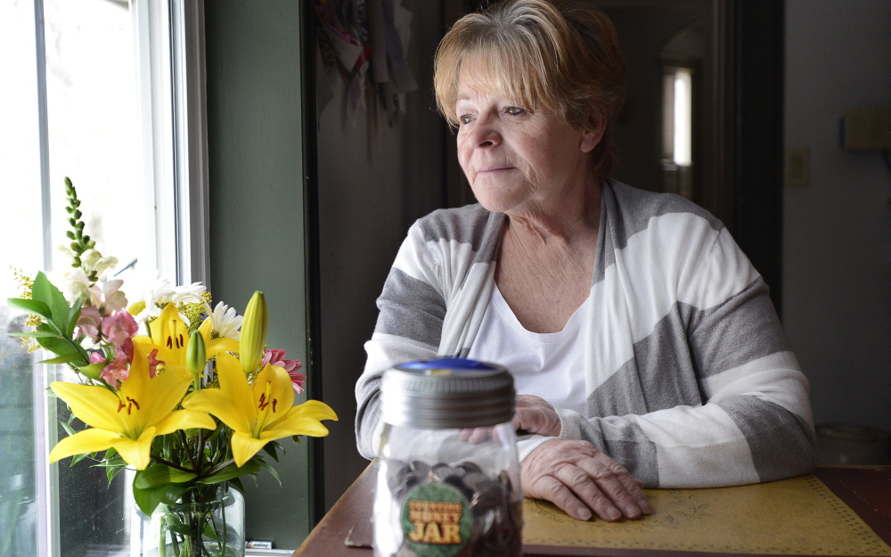 “I am embarrassed that I still smoke,” says Linda Dennison, 64, of Baldwin, whose results from a Mercy Hospital CT scan came back negative for lung cancer. Newly determined to quit after the recent death of her brother, a heavy smoker, Dennison socks away coins in a jar, foreground, to show the money she saves from not smoking.