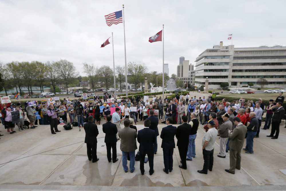 Demonstrators in favor of a religious freedom bill that Arkansas Gov. Asa Hutchinson wanted rewritten, foreground, gather at the Arkansas state Capitol in Little Rock, Ark., as opponents, left, demonstrate against the bill, on Thursday. A reworked bill was passed and the governor says he’ll sign it.