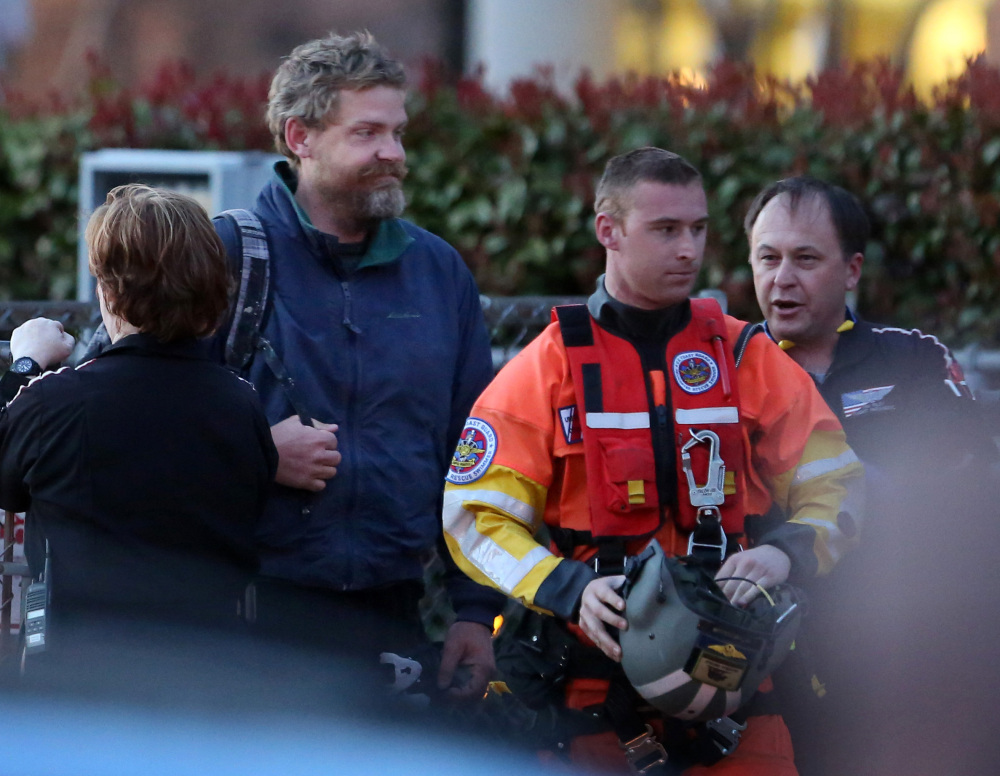 Louis Jordan, with beard, walks from the Coast Guard helicopter to the Sentara Norfolk General Hospital in Norfolk, Va., after being found off the North Carolina coast Thursday. His family says he sailed out of a marina in Conway, S.C., on Jan. 23, and hadn’t been heard from since.