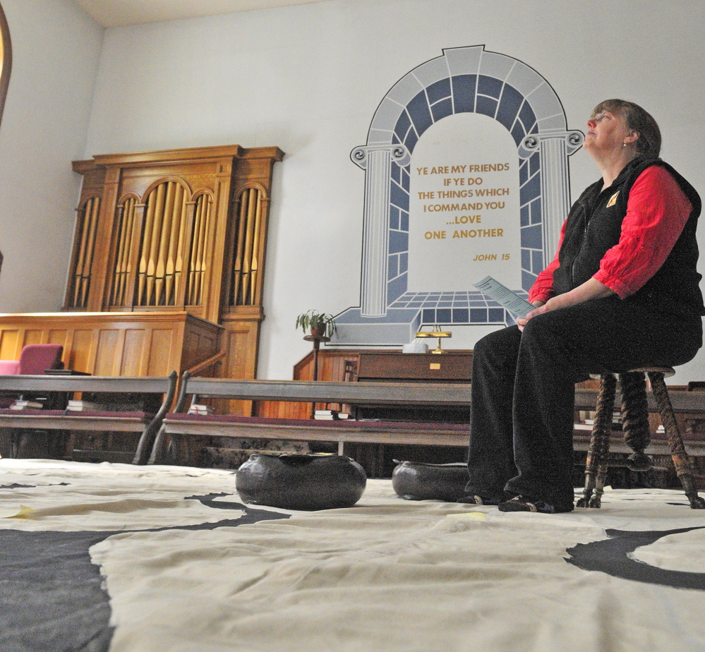 Jenifer Lewis sits on a stool meditating at the center of the labyrinth Friday in the Winthrop Center Friends Meeting House, where the St. Andrew’s Episcopal Church meets.