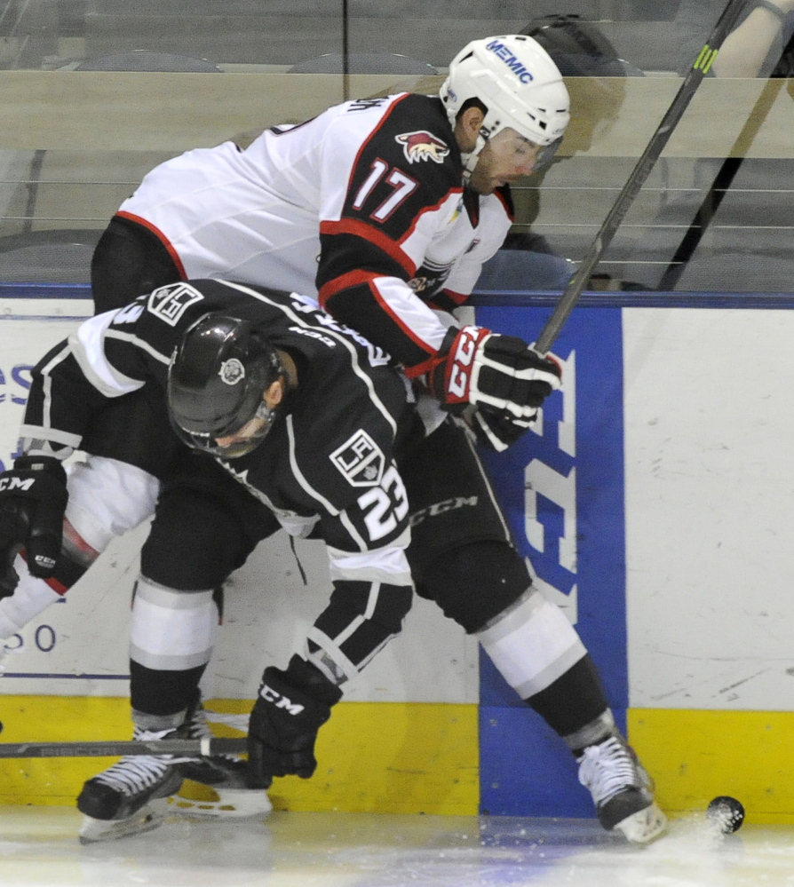 Jordan Martinook of the Pirates is pinched against the boards by Manchester’s Nick Ebert. The league-leading Monarchs rallied to beat Portland for the seventh time in 10 meetings this season.