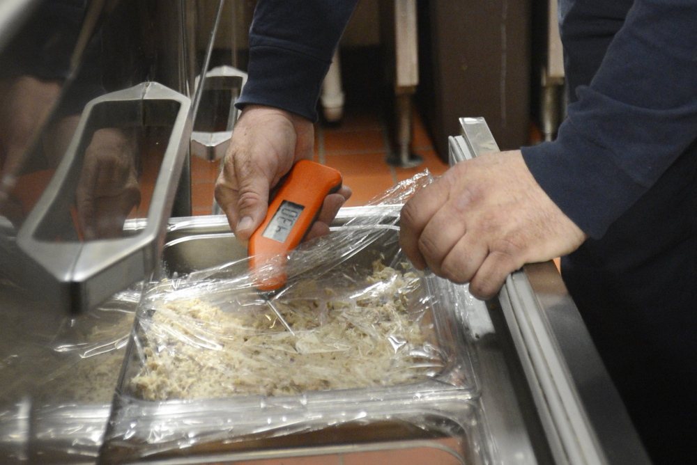 A thermometer allows an inspector to gauge whether food is being stored properly, one of many potential violations. Under the  proposed bill the cost of hiring new inspectors would be paid through an increase in licensing fees paid by restaurant owners. Shawn Ouellette / Staff Photographer