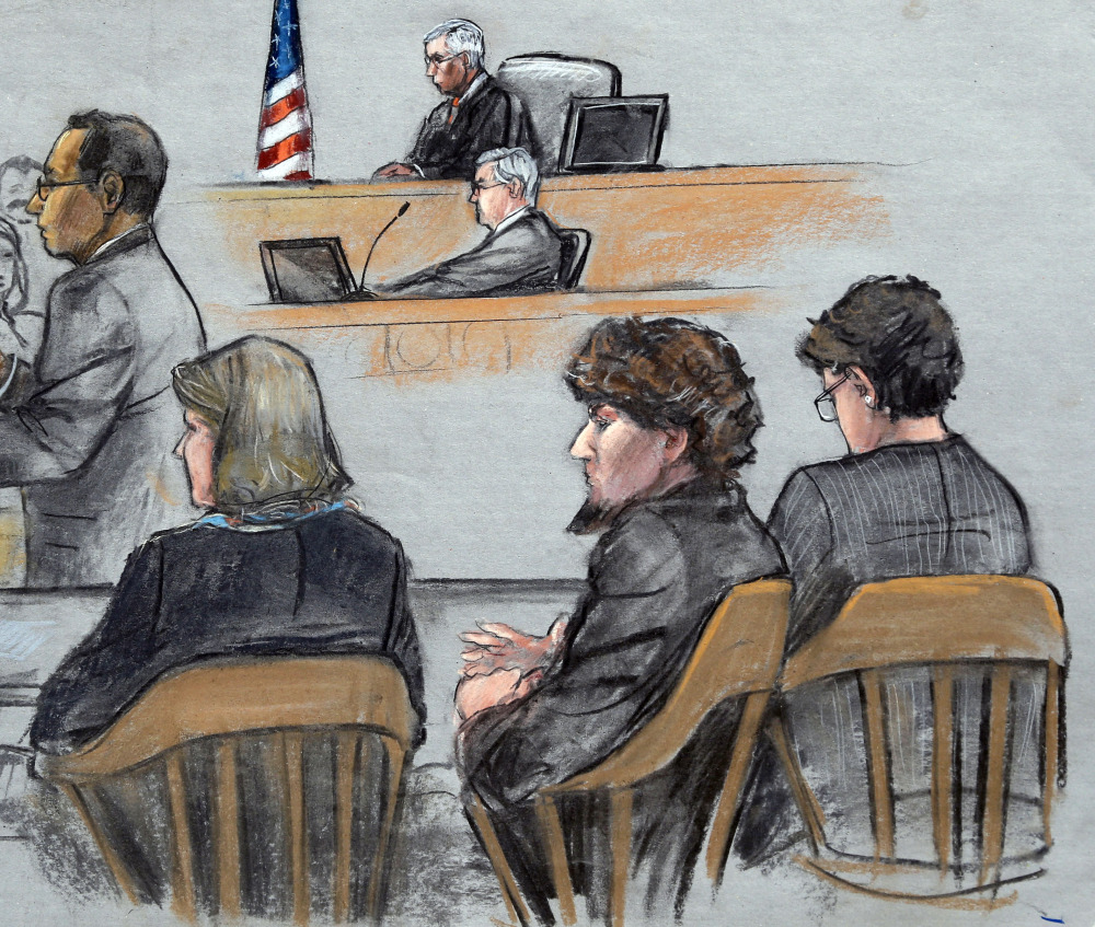 In this courtroom sketch, Assistant U.S. Attorney Aloke Chakravarty, left, is depicted addressing the jury as defendant Dzhokhar Tsarnaev, second from right, sits between his defense attorneys during closing arguments in Tsarnaev's federal death penalty trial Monday, April 6, 2015, in Boston. Tsarnaev is charged with conspiring with his brother to place two bombs near the Boston Marathon finish line in April 2013, killing three and injuring 260 people. (AP Photo/Jane Flavell Collins)