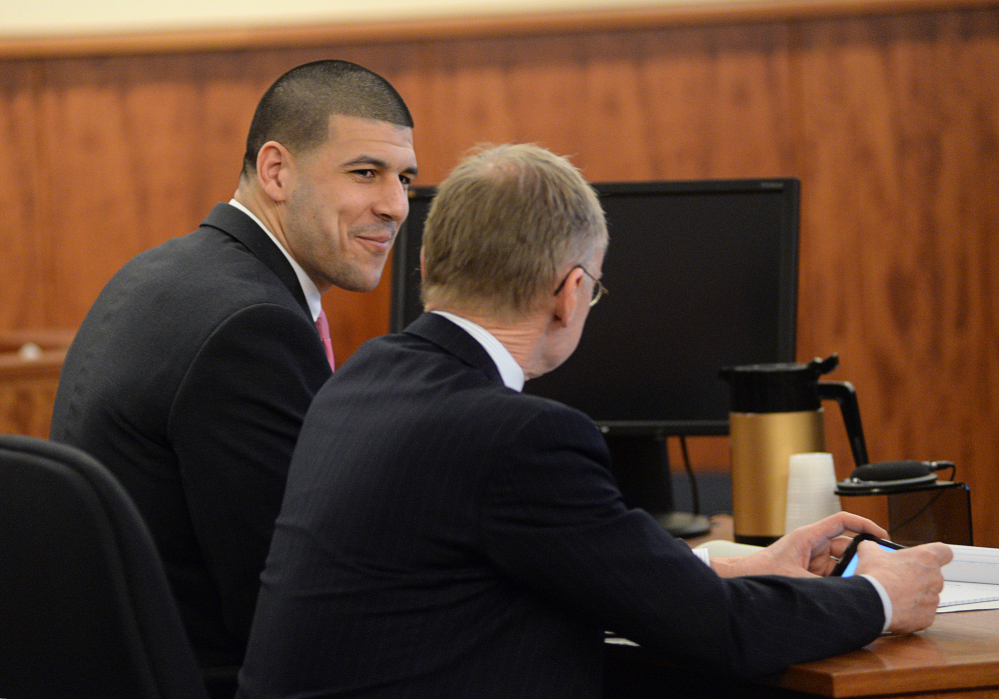 Former New England Patriots football player Aaron Hernandez smiles with defense attorney Charles Rankin in the courtroom of the Bristol County Superior Court House in Fall River, Mass., on Wednesday. The fate of Hernandez is now in the hands of a jury, which began its first full day of deliberations Wednesday.