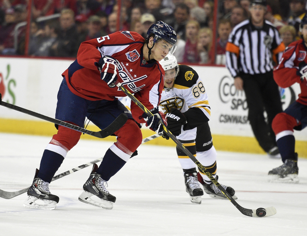 Washington Capitals left wing Andre Burakovsky carries the puck against Bruins right wing David Pastrnak during the first period of Wednesday night’s game in Washington. The Capitals shut out the Bruins, 3-0.