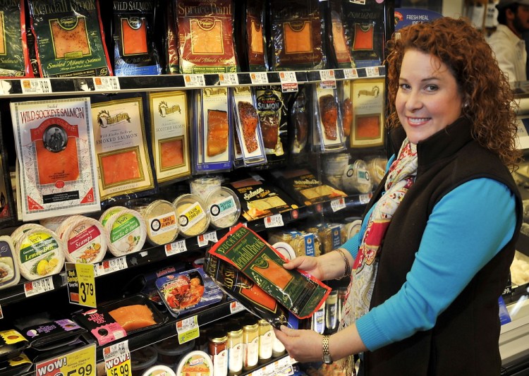 Kasey Harris, sustainability specialist at Hannaford, checks over seafood prodcuts at the market.