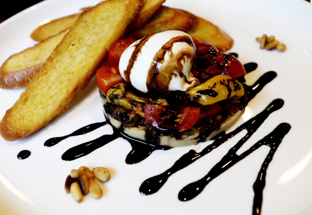 Eve’s comforting burrata appetizer features the cheese served atop cherry tomatoes and olives with a sprinkling of pine nuts.