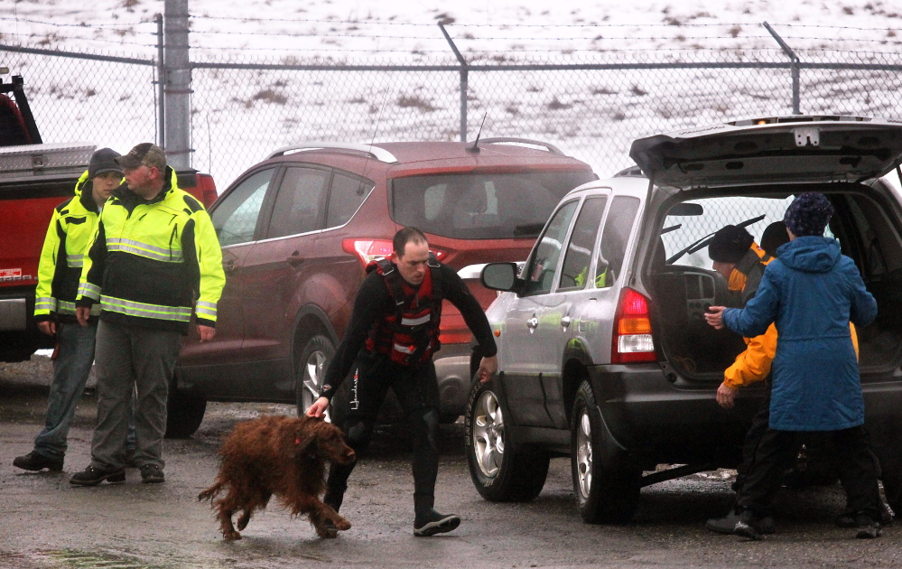 Keeli, an Irish Setter who spent about 30 minutes in the frigid waters of the Kennebec River after slipping in while chasing ducks, is brought to friends of her owner shortly after being rescued on Friday.
