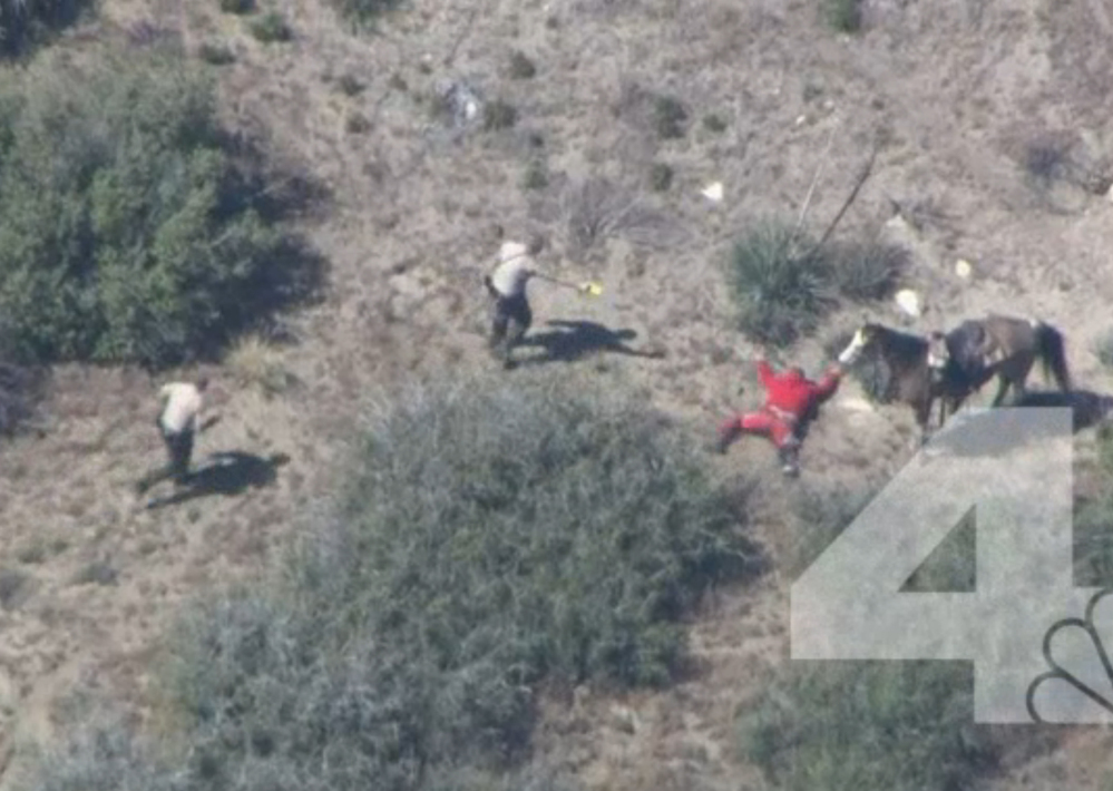 A Southern California sheriff on Thursday ordered an immediate investigation after deputies were recorded beating and kicking a man who fled in a car and on horseback. This KNBC-TV video frame shows officers near the man in Apple, Valley, Calif., on Thursday.