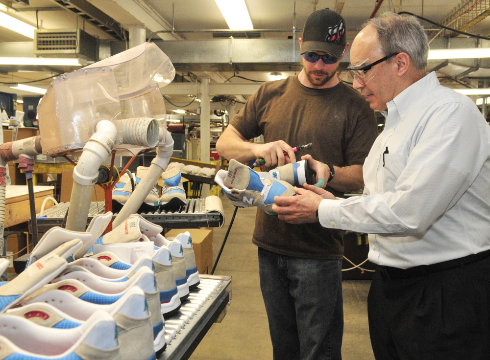 Jason Flanders, left, tells U.S. Rep. Bruce Poliquin, R-2nd District, about the model 998 shoes he’s making during a tour of the New Balance factory on Friday in Norridgewock.