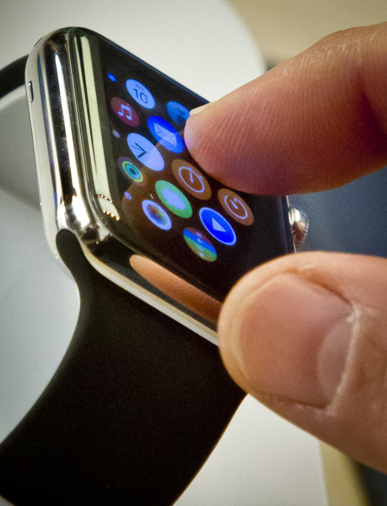 A customer examines Apple's new watch, Friday, April 10, 2015, in New York. Apple has started taking orders for the watch on its website and the Apple Store app. Currently, that's the only way Apple is selling the watch, with shipments scheduled to start April 24.  (AP Photo/Bebeto Matthews)
