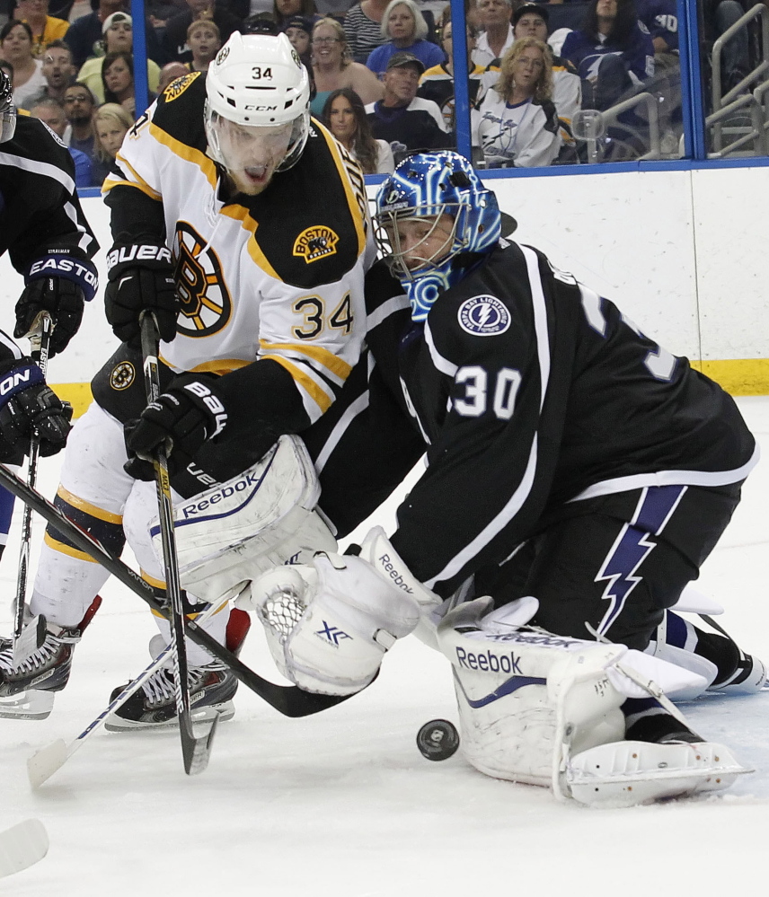 Tampa Bay goalie Ben Bishop makes a save as Carl Soderberg of the Bruins looks for the rebound Saturday night. Boston’s season ended in fitting fashion with a 3-2 shootout loss.