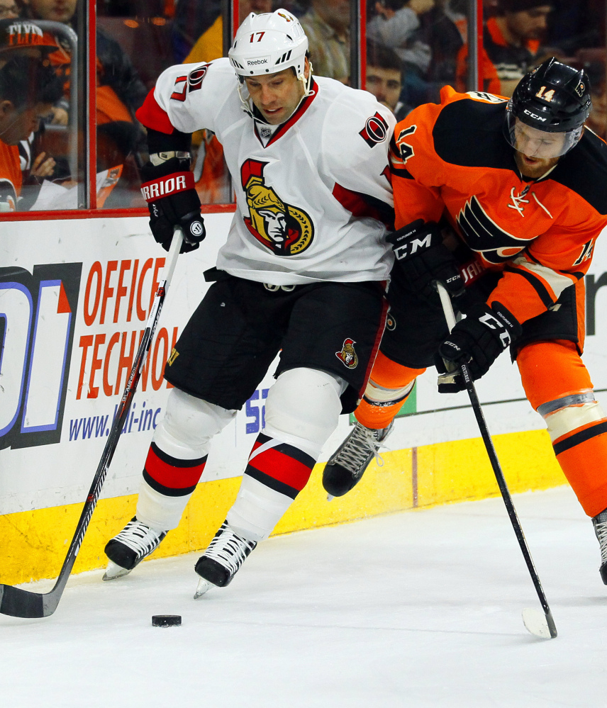 David Legwand, left, of the Senators and Sean Couturier of the Flyers fight for the puck Saturday in Philadelphia. The Senators won 3-1, assuring themselves of at least a wild-card berth.