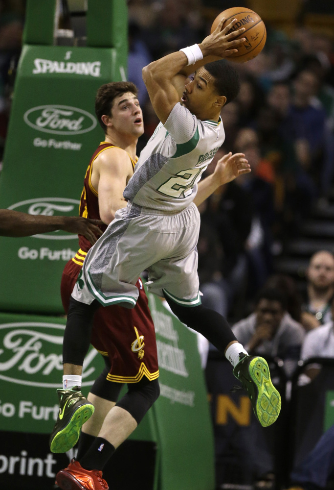 Boston Celtics guard Phil Pressey catches a rebound in front of Cleveland Cavaliers guard Joe Harris in the fourth quarter Sunday in Boston. The Celtics won 117-78. The Associated Press