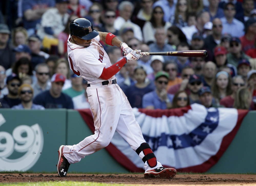 Boston Red Sox’s Mookie Betts hits a three-run home run in the second inning of the Sox home opener Monday in Boston.