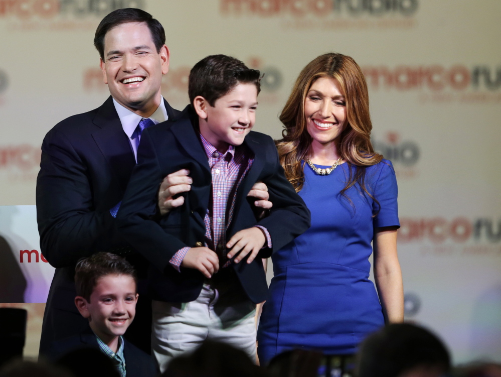 Sen. Marco Rubio holds his son Anthony after having announced that he will be running for the Republican presidential nomination, during a Monday rally in Miami. Also shown are his wife Jeanette and son Dominic.