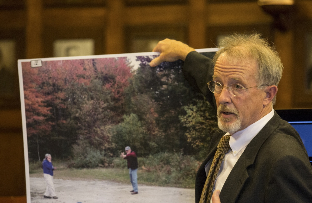 Prosecutor John Alsop displays a photo taken just after Merrill 'Mike' Kimball shot Leon Kelley in 2013. At left in the photo is Kimball's wife, Karen Thurlow-Kimball. The view of Kelley has been cropped out of the foreground. 
Whitney Hayward/Staff Photographer