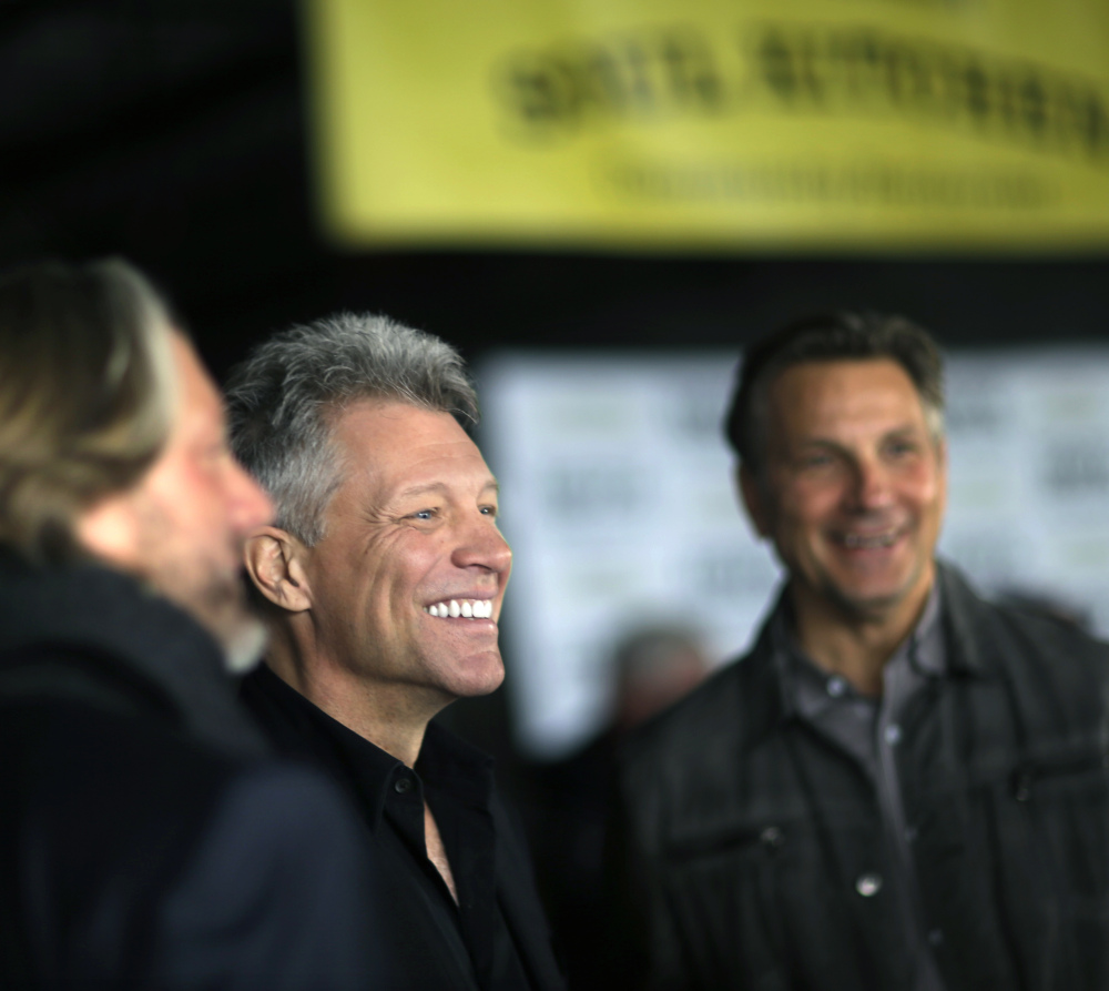 Singer Jon Bon Jovi, center, announces his foundation will open a social services center in hurricane-ravaged Toms River, N.J., later this year.