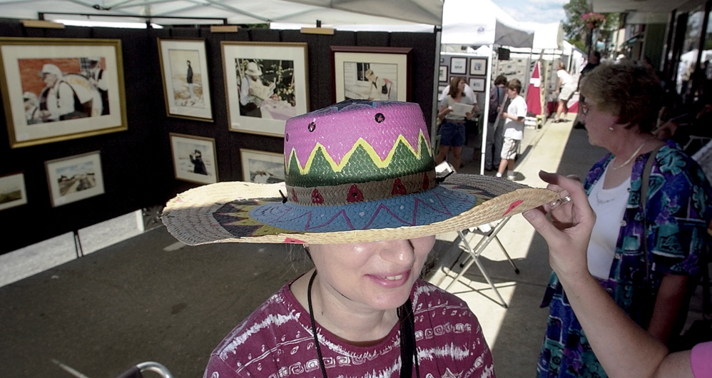 Barbara McPherson’s hat draws the attention of a friend during her stroll through Waterville’s Arts Fest in 2012.
