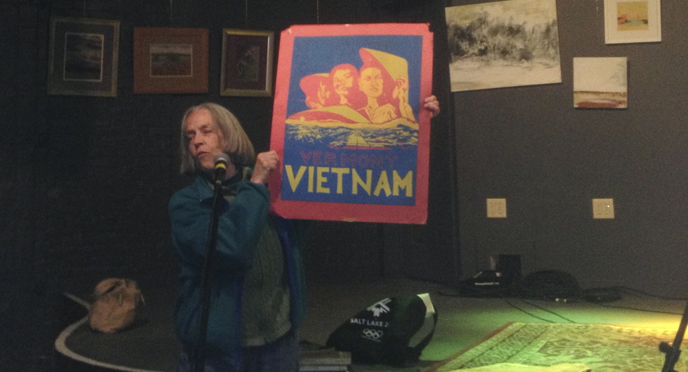 Barbara Nolfi, who was part of a Franklin, Vt., farming commune, holds up an artifact from the 1970s at a forum held by the Vermont Historical Society in Burlington, Vt.