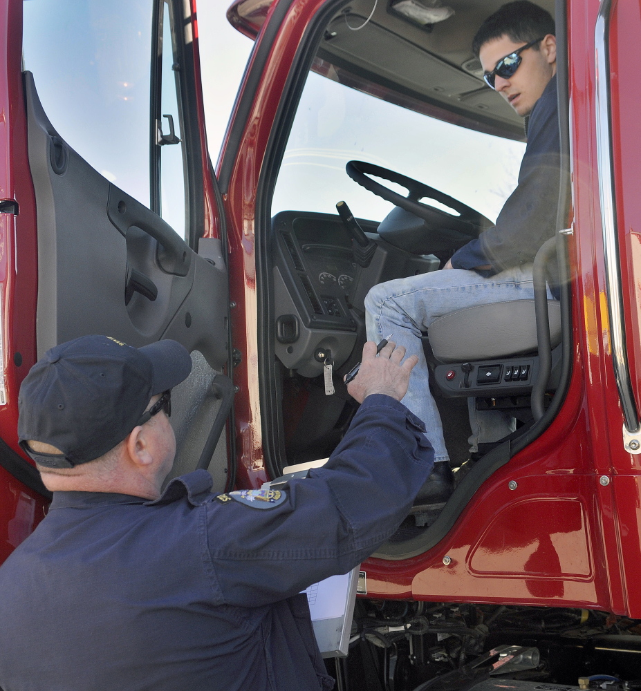 Parker Gardner, 17, of Lincoln and state Trooper Chris Foxworthy inspect a truck during a student driving competition Wednesday at the Augusta Civic Center.
