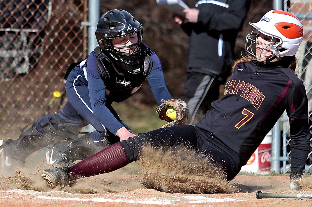 Yarmouth catcher Kallie Hutchinson applies a late tag Thursday as Tess Haller of Cape Elizabeth crosses the plate in the fourth inning of their softball opener Thursday. Yarmouth scored seven runs in the seventh inning for an 11-4 victory.