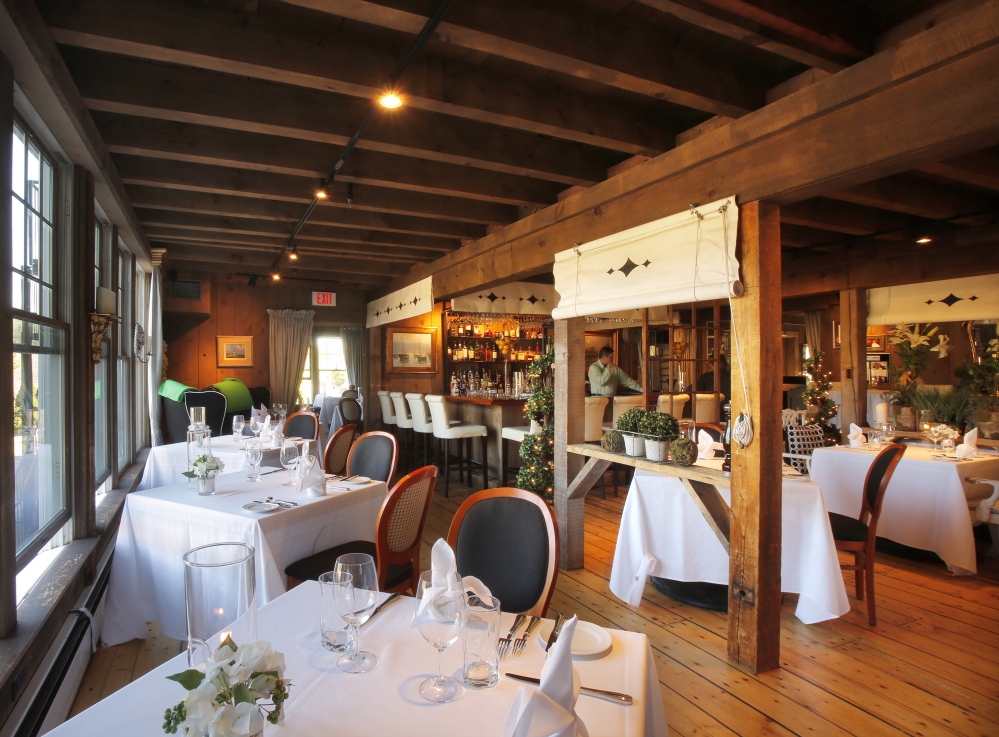 The dining areas of On the Marsh Bistro in Kennebunk are decorated with upholstered furniture, ornate wooden chandeliers, patterned pillows and oil lamps on every table.