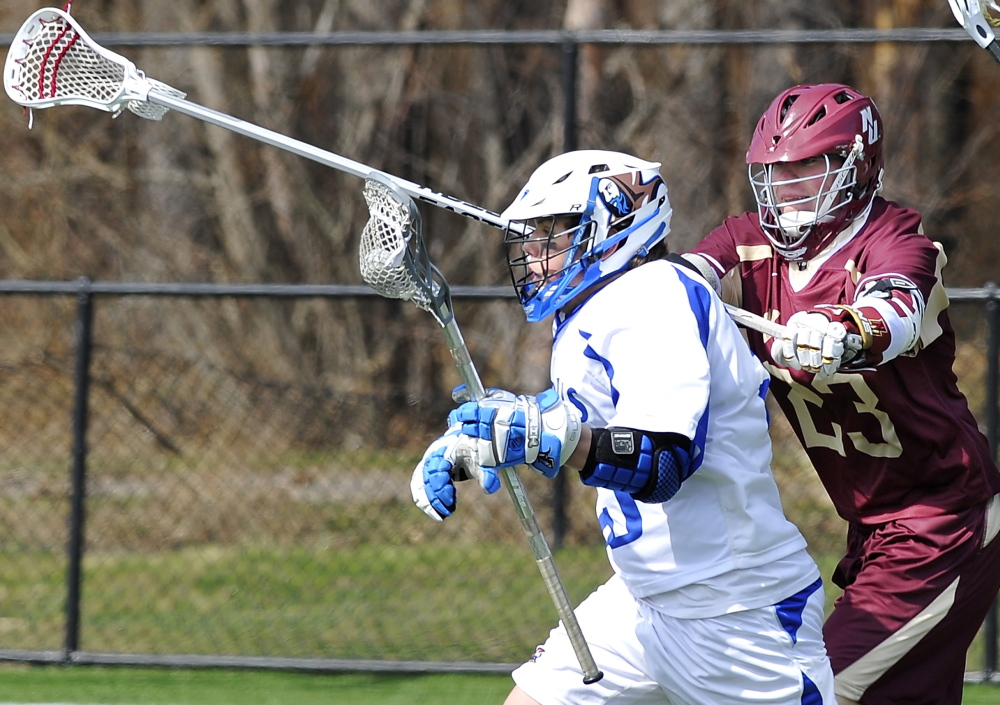 Luigi Grimaldi of St. Joseph’s College gets checked by Norwich’s Thomas Carlson as Grimaldi heads toward the goal in a men’s lacrosse game Saturday at Deering High. Norwich won, 9-3.