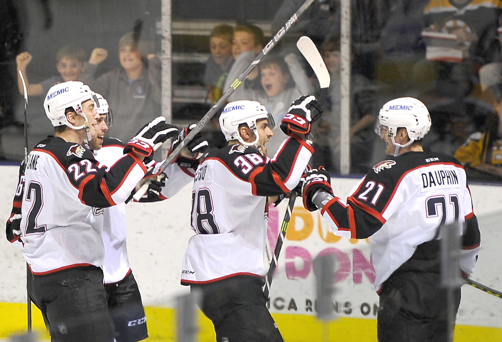 Laurent Dauphin, right, celebrates with his teammates after scoring Portland’s second goal Saturday night in a 3-2 over the Providence Bruins at Cross Insurance Arena.