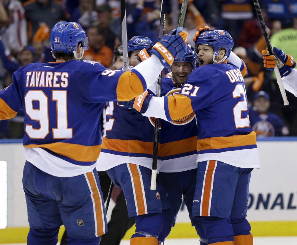 New York Islanders’ Kyle Okposo, right, celebrates with teammates after scoring in the second period Sunday in Uniondale, N.Y.